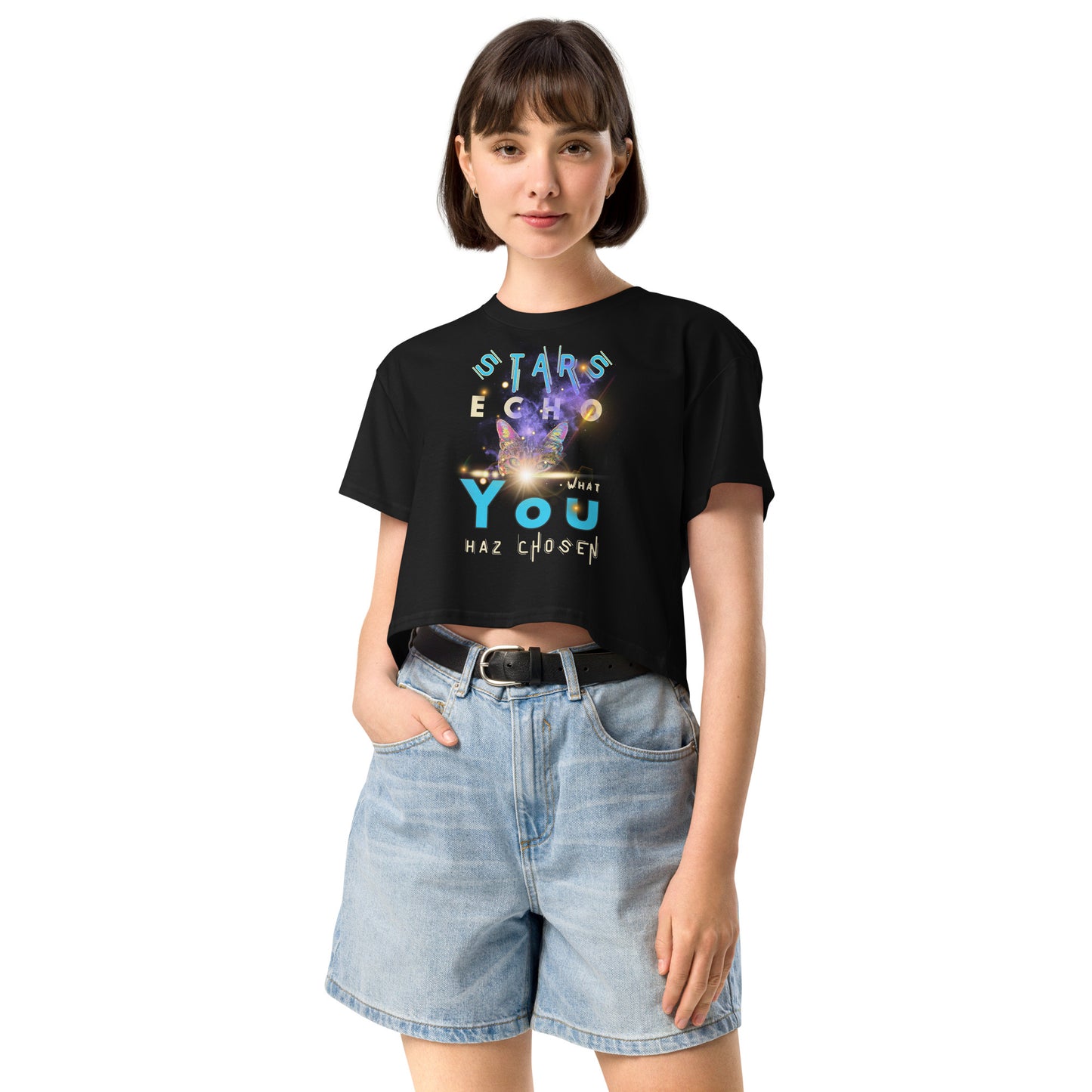Person wearing a black t-shirt with a graphic design and text, paired with light blue denim shorts on a white background.