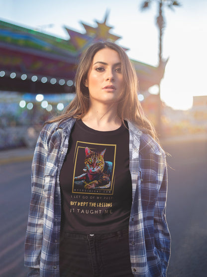 beautiful young woman outside in a theme park at sunset wearing a plaid shirt, black jeans and a black crop top featuring a gold framed cat with a cut ear laying down and says, i let go of my past but kept the lessons it taught me, mysocialcat.com