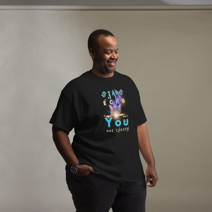 Man wearing a black t-shirt with colorful text and graphics on a plain background