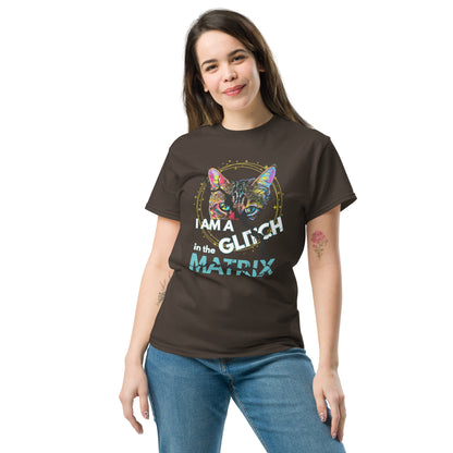 A woman modeling a dark brown graphic t-shirt with a colorful cat illustration and the text 'I AM A GLITCH IN THE MATRIX'. She is wearing blue jeans against a plain white background.
