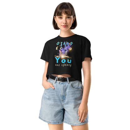 Person wearing a black t-shirt with a graphic design and text, paired with light blue denim shorts on a white background.